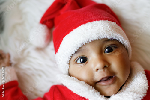 Cute baby wearing santa claus costume smiling at camera photo