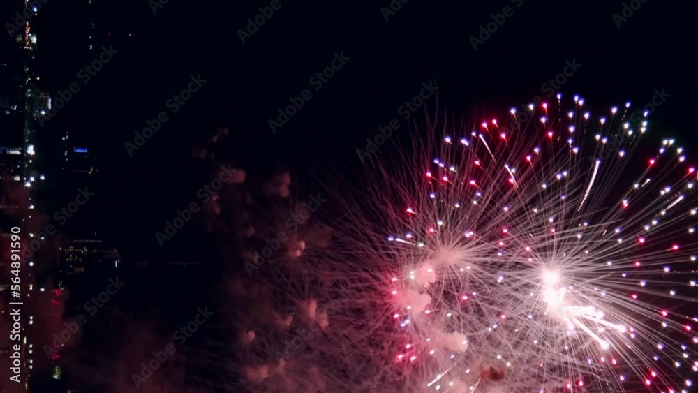 Fireworks display celebration for New year's eve with abstract multicolor big shining glowing fireworks show with bokeh lights in the night sky. Vertical Footage Fireworks display celebration for New year's eve with abstract multicolor big shining glowing fireworks show with bokeh lights in the night sky. Vertical Footage