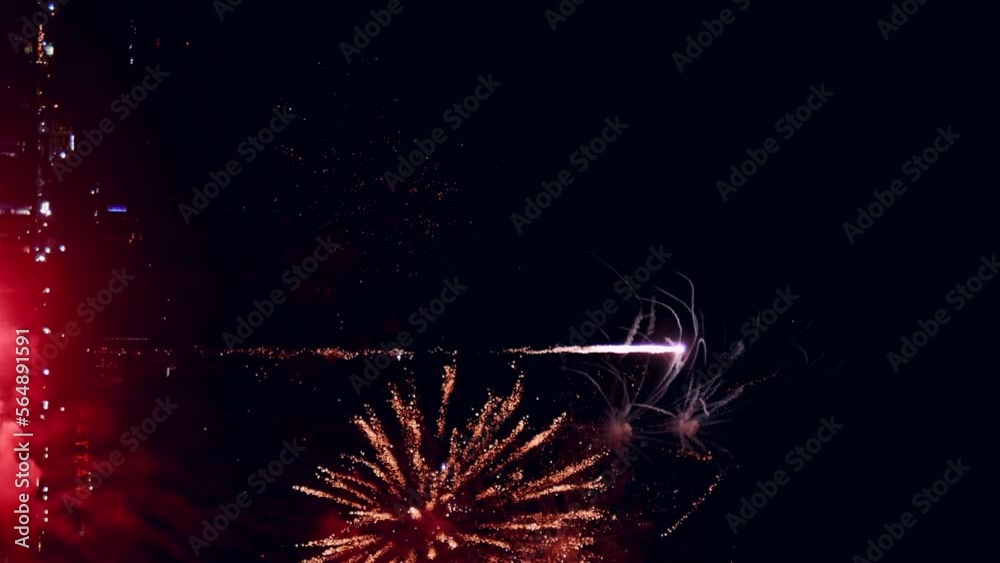 Fireworks display celebration for New year's eve with abstract multicolor big shining glowing fireworks show with bokeh lights in the night sky. Vertical Footage Fireworks display celebration for New year's eve with abstract multicolor big shining glowing fireworks show with bokeh lights in the night sky. Vertical Footage