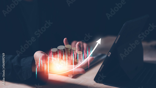 investment and finance concept, businessman holding virtual trading graph and blurred coins on hand, stock market, profits and business growth..saving and investment plans retirement and fund photo