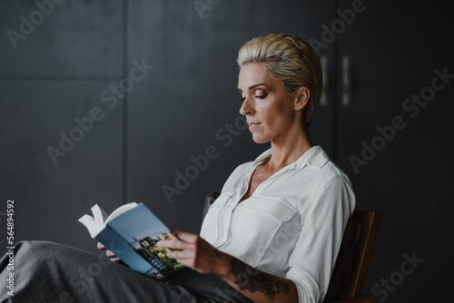 business woman in her office reading a book photo
