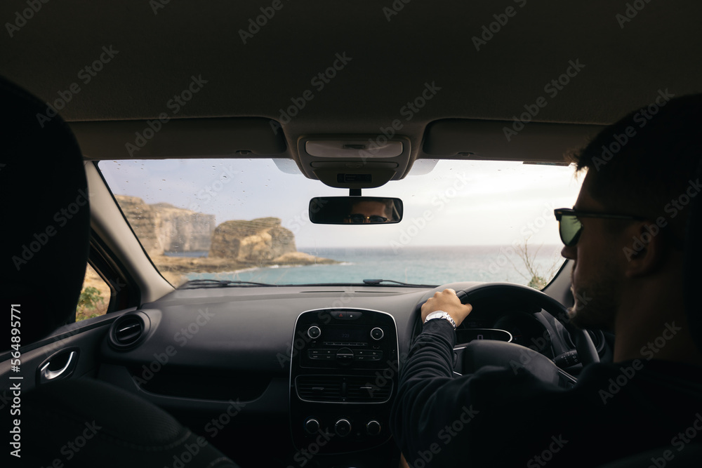 Man driving a car with the steering wheel on the right hand side