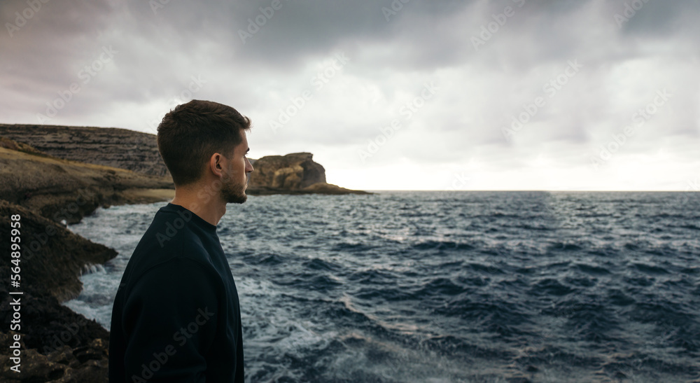 Man looking at the cliffs where the Azure Window of Malta was Man looking at the cliffs where the Azure Window of Malta was