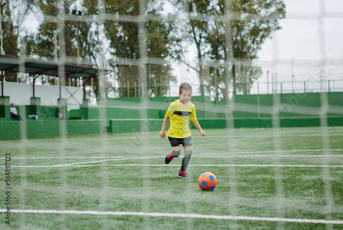 Little boy dribbling football