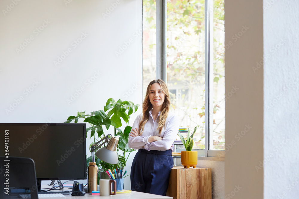 Businesswoman with crossed arms standing near window Businesswoman with crossed arms standing near window
