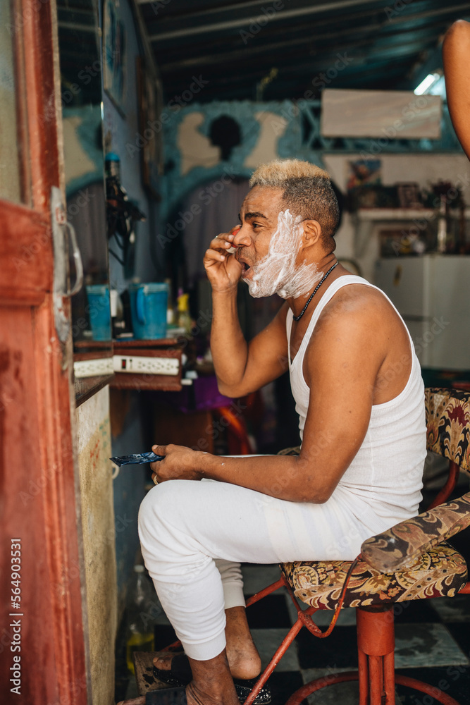 Careful Cuban barber shaving face in Old Havana Careful Cuban barber shaving face in Old Havana