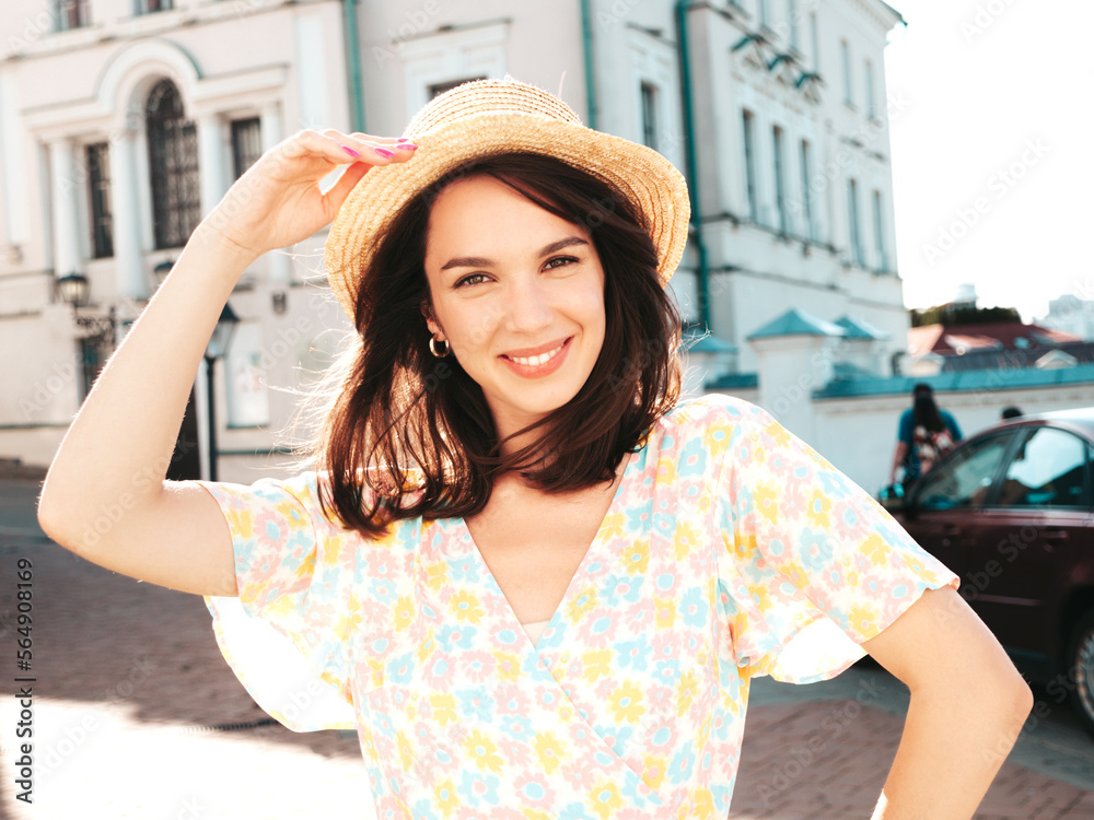 Beautiful smiling brunette model. Trendy female posing in the street background. Funny and positive woman having fun outdoors at sunset. In hat at sunny day. In dress, sunglasses