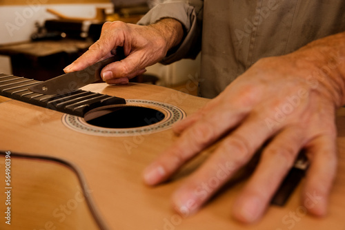 Crop luthier working in custom classic guitar photo