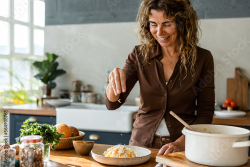 Smiling woman serving risotto with pumkin photo