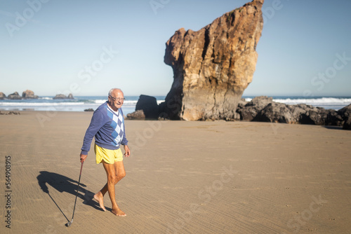 senior man playing golf on the beach