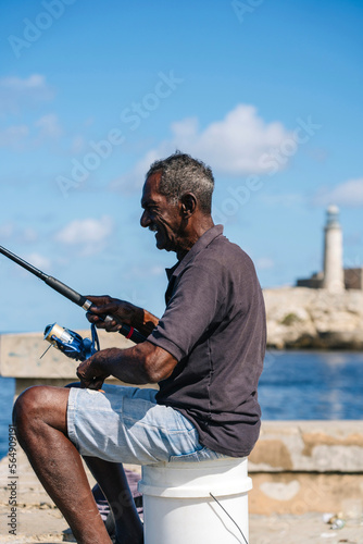Aged attentive fisher man catching fish in Cuba