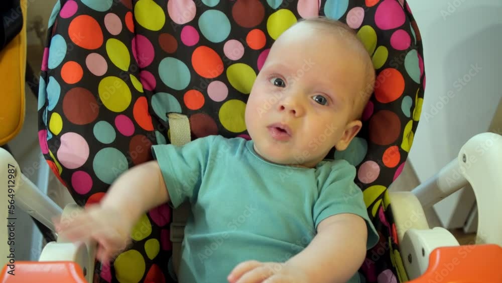 The baby sits in a chair and shows emotions. The baby sits in a chair and shows emotions.