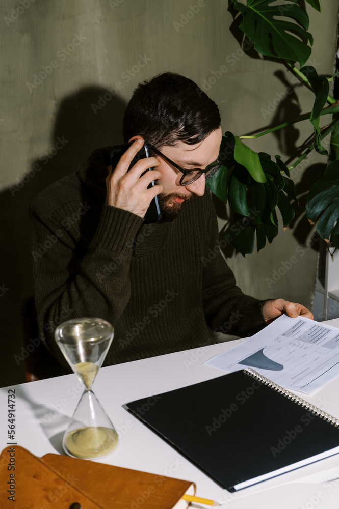Man talking on phone in his home office Man talking on phone in his home office