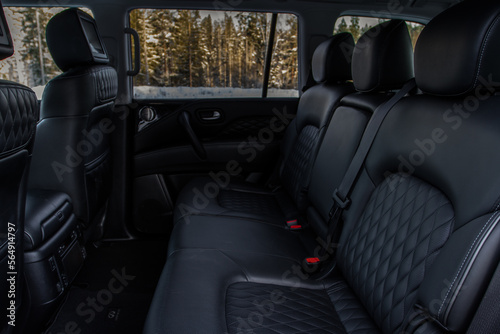 Modern car interior. Clean rear seats with the belts. Three rear seats in the row. Leather light back passenger seats.