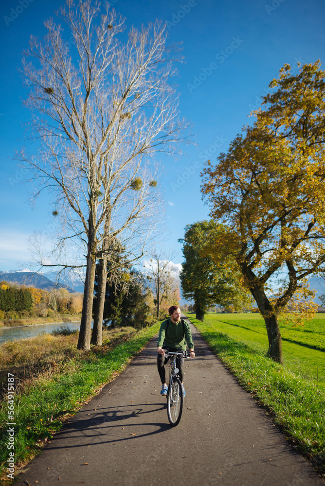 Young man riding bicycle in park at autumn Young man riding bicycle in park at autumn