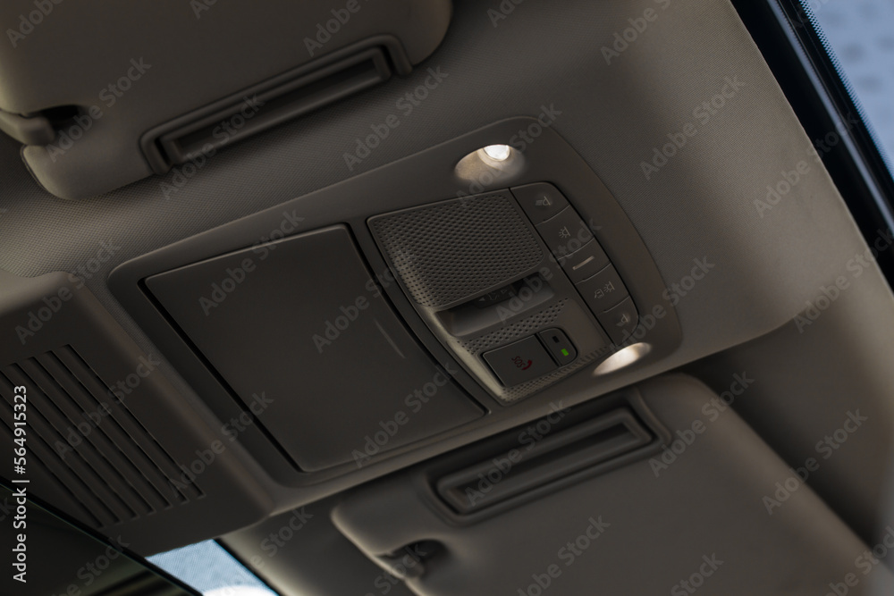 Close up image of the SOS button and car ceiling lamp in a car.