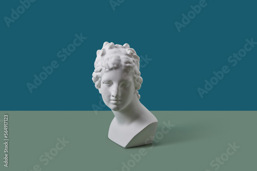 White Aphrodite bust on blue and green background. photo