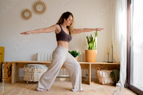 Female practicing yoga postures from home