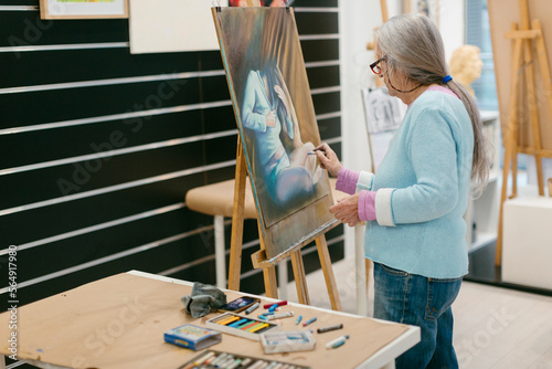 Woman painting with pastel technique in art school studio