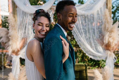 Happy diverse couple against wedding canopy