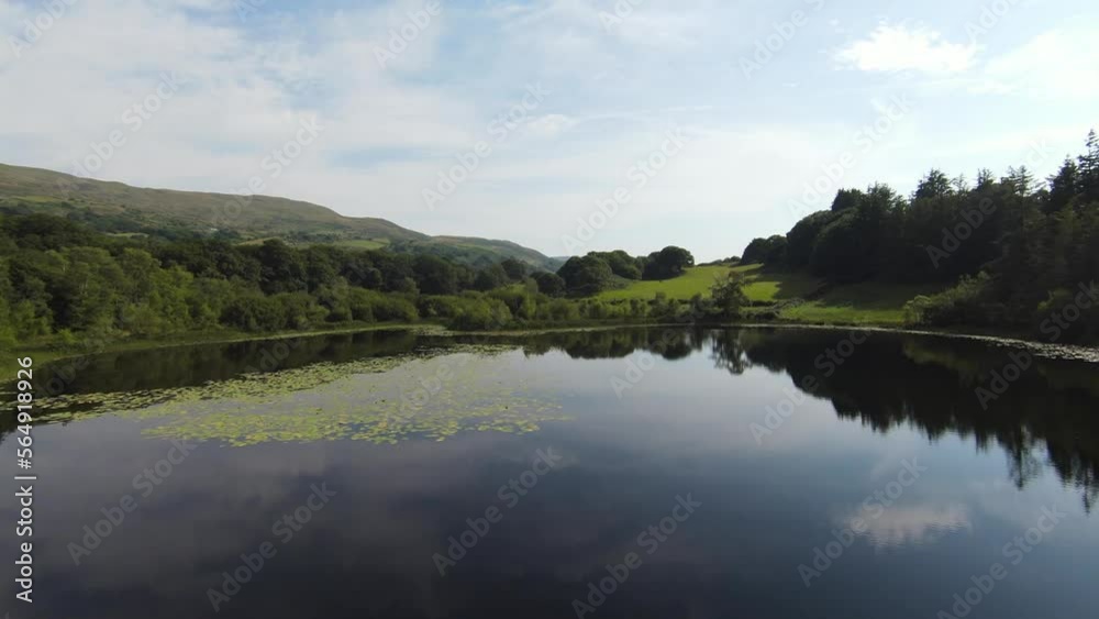 Fast Fpv shot of the reflection of the sky on a lake in Wales