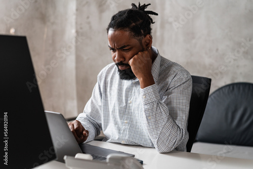 Man In The Office Looking At Computer And Frowns