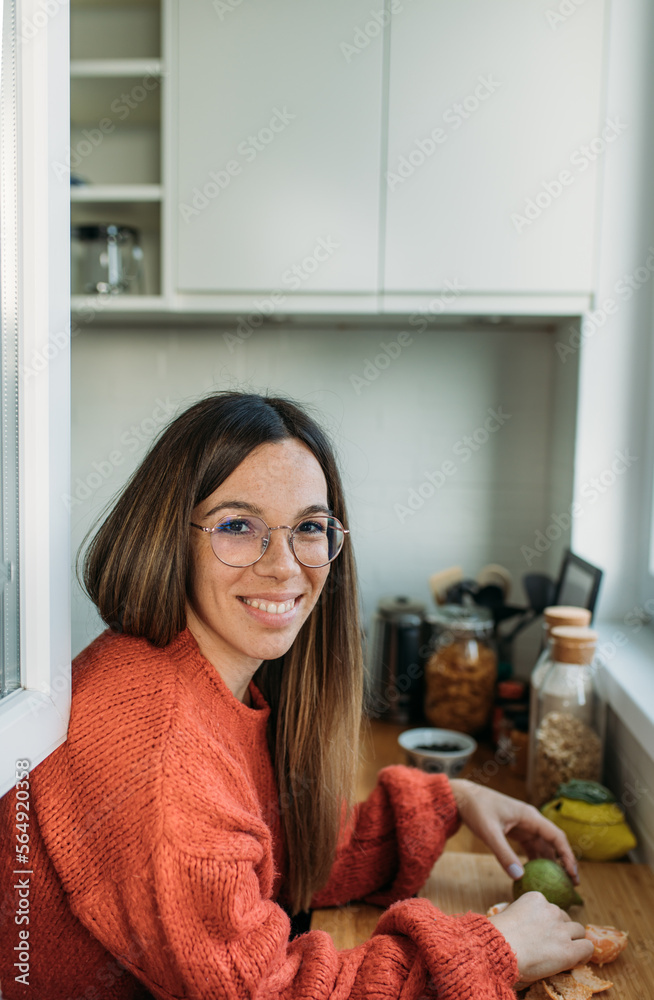 Beautiful Woman Peeling Orange in Her Kitchen Beautiful Woman Peeling Orange in Her Kitchen