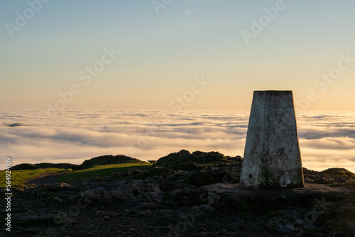 A trig point on top of a hill photo