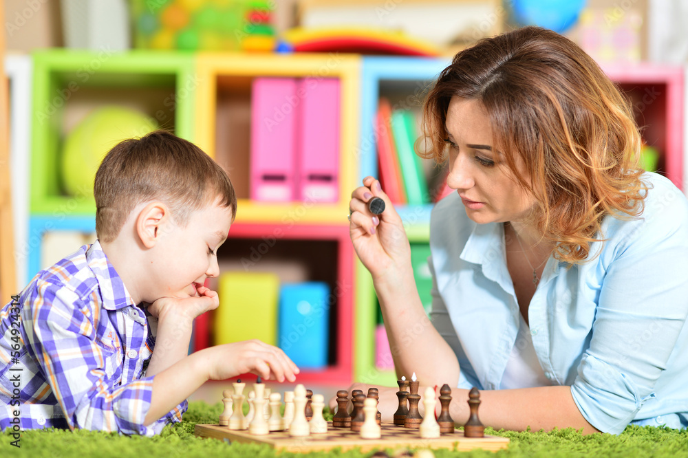Fototapeta premium mother with son playing chess at home