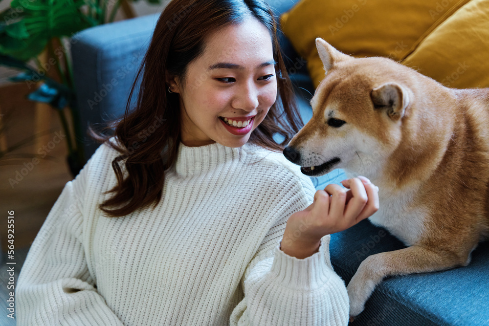 Woman enjoying with her dog at home.
