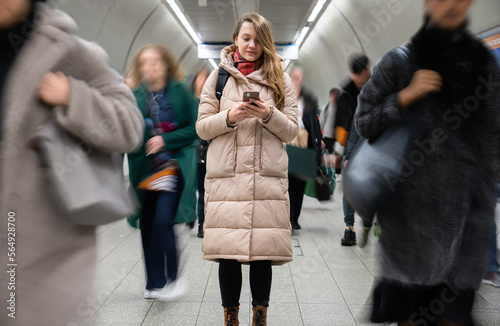 Woman Using Phone Between People In Motion
