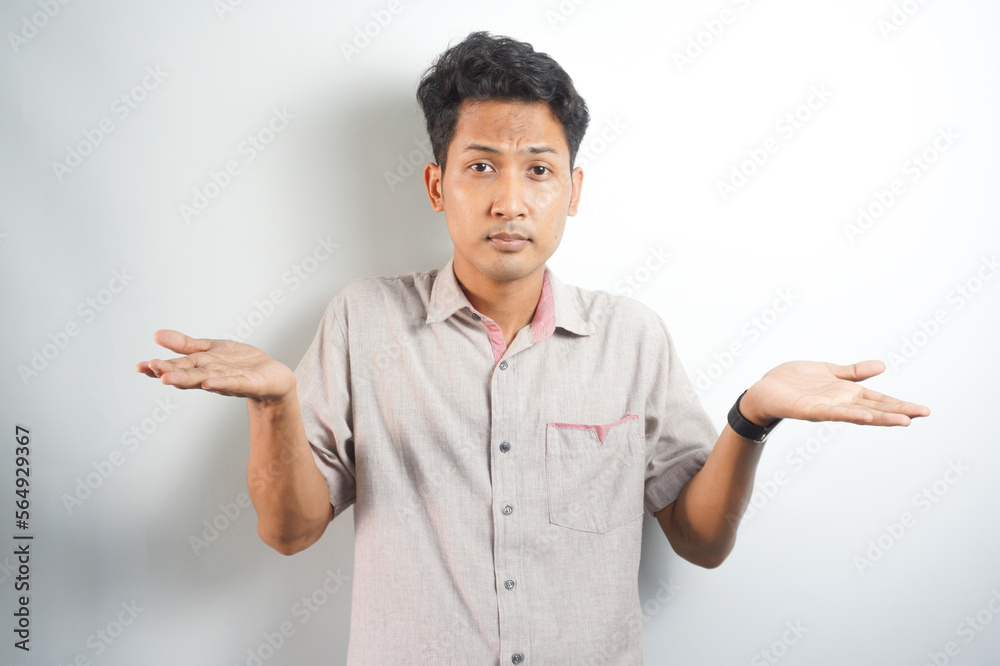 Handsome asian young man wearing shirt standing on white background confused and wondering about question. Uncertain with doubt, thinking. dream concept Handsome asian young man wearing shirt standing on white background confused and wondering about question. Uncertain with doubt, thinking. dream concept