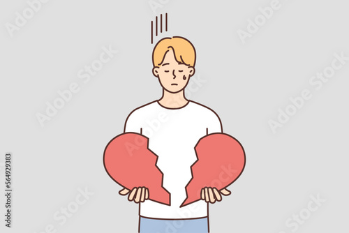 Unhappy man hold broken heart in hands 