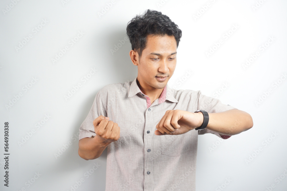 Happy and surprised Asian man who is looking at his watch. Shocked asian man in casual looking at watch Happy and surprised Asian man who is looking at his watch. Shocked asian man in casual looking at watch