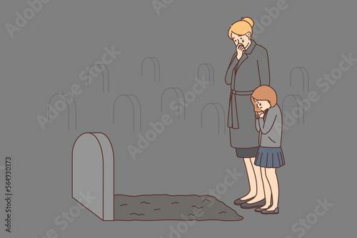 Depressed woman and child crying at tombstone 