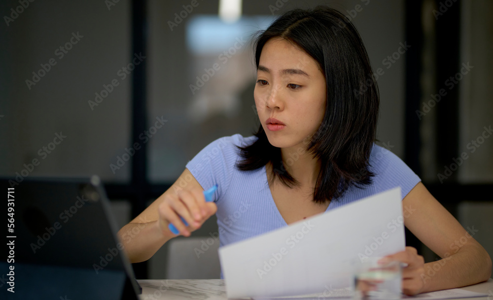 Asian freelancer checking data on tablet Asian freelancer checking data on tablet