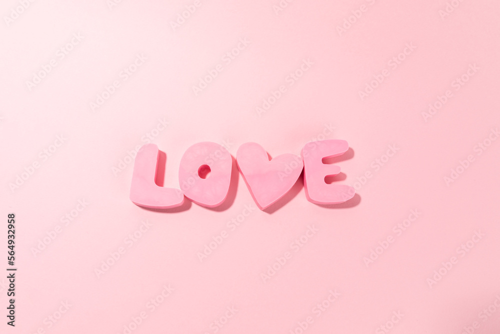 Word LOVE made of pink bubble letters and a heart on a pink background