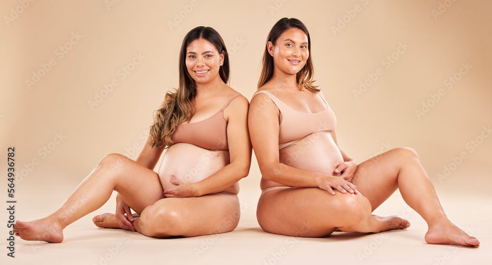 Women, portrait or sitting and pregnancy stomach, tummy growth progress or baby healthcare wellness on studio background. Smile, happy or friends in pregnant underwear for solidarity support or love Women, portrait or sitting and pregnancy stomach, tummy growth progress or baby healthcare wellness on studio background. Smile, happy or friends in pregnant underwear for solidarity support or love