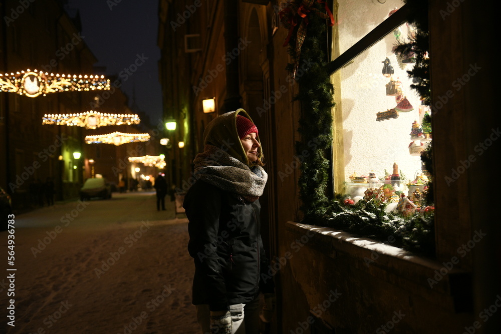 woman looking at the showcase of a gift shop, christmas time in europe woman looking at the showcase of a gift shop, christmas time in europe