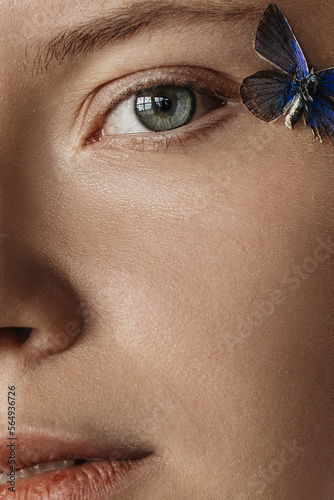 Close Up woman's portrait with grey eyes and blonde hair and butterfly