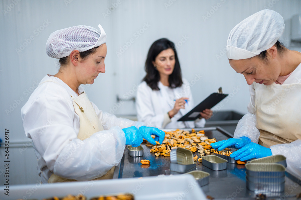 Employees of factory canning seafood product Employees of factory canning seafood product