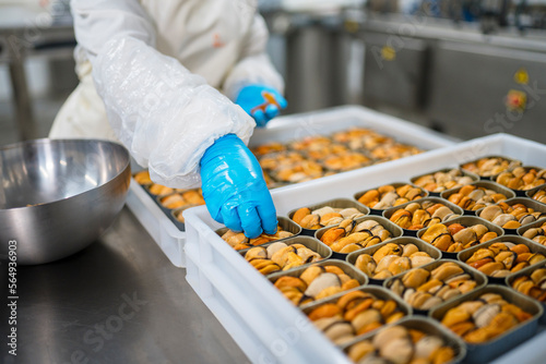 Crop worker adding ingredients to canned mussels
