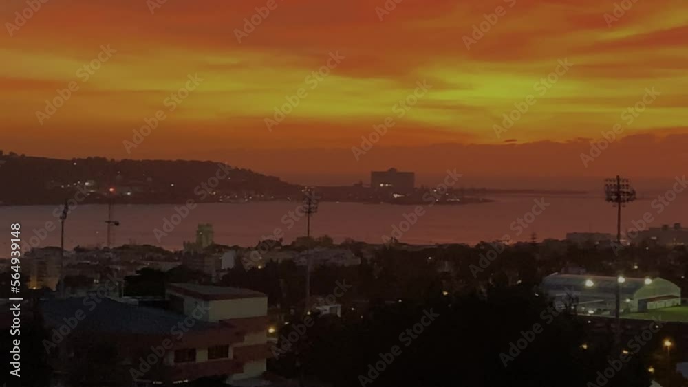 aerial view of caparica from Lisbon over river Tagus in orange silhouette sky aerial view of caparica from Lisbon over river Tagus in orange silhouette sky