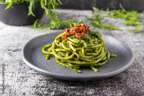 Gragnano spaghetti with homemade rocket pesto and dried tomatoes. Dish suitable for adults and children, healthy and tasty. photo