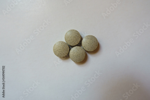 Top view of four beige round pills of iron bisglycinate dietary supplement photo