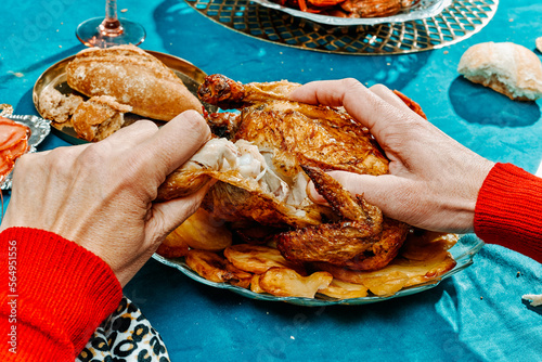 man rips off the leg of a roast turkey photo