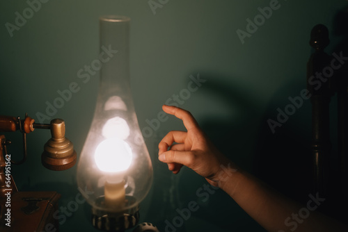 Young woman touches lamp photo