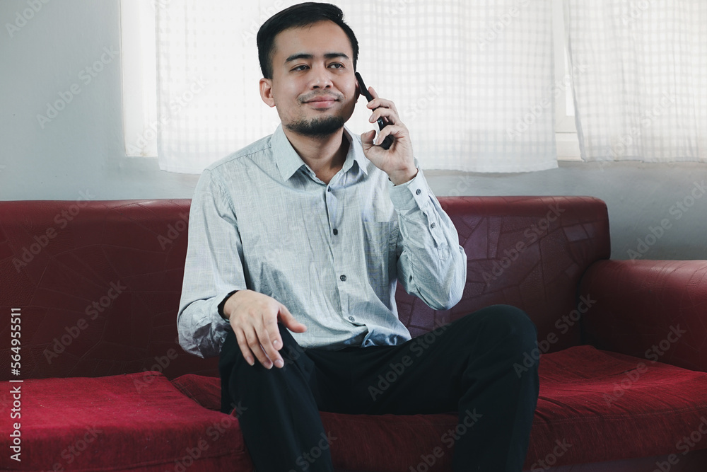 Young Asian man with beard is exciting and smiling when he saw the phone in his hand and knew happy result from it. He raising another hand to cheer it up.
Young Asian man with beard is exciting and smiling when he saw the phone in his hand and knew happy result from it. He raising another hand to cheer it up.
