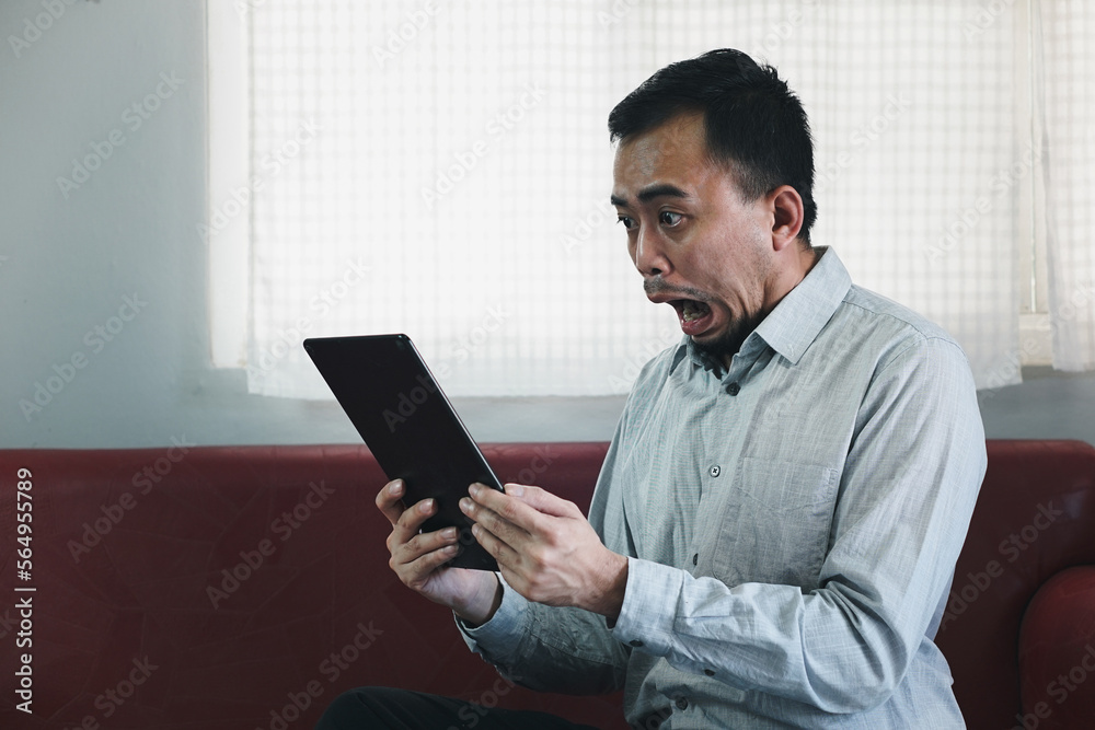 Young Asian man with beard is exciting and smiling when he saw the phone in his hand and knew happy result from it. He raising another hand to cheer it up.
Young Asian man with beard is exciting and smiling when he saw the phone in his hand and knew happy result from it. He raising another hand to cheer it up.