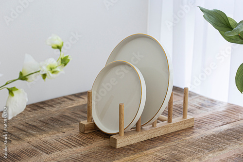Clean dishes on wooden drying rack photo
